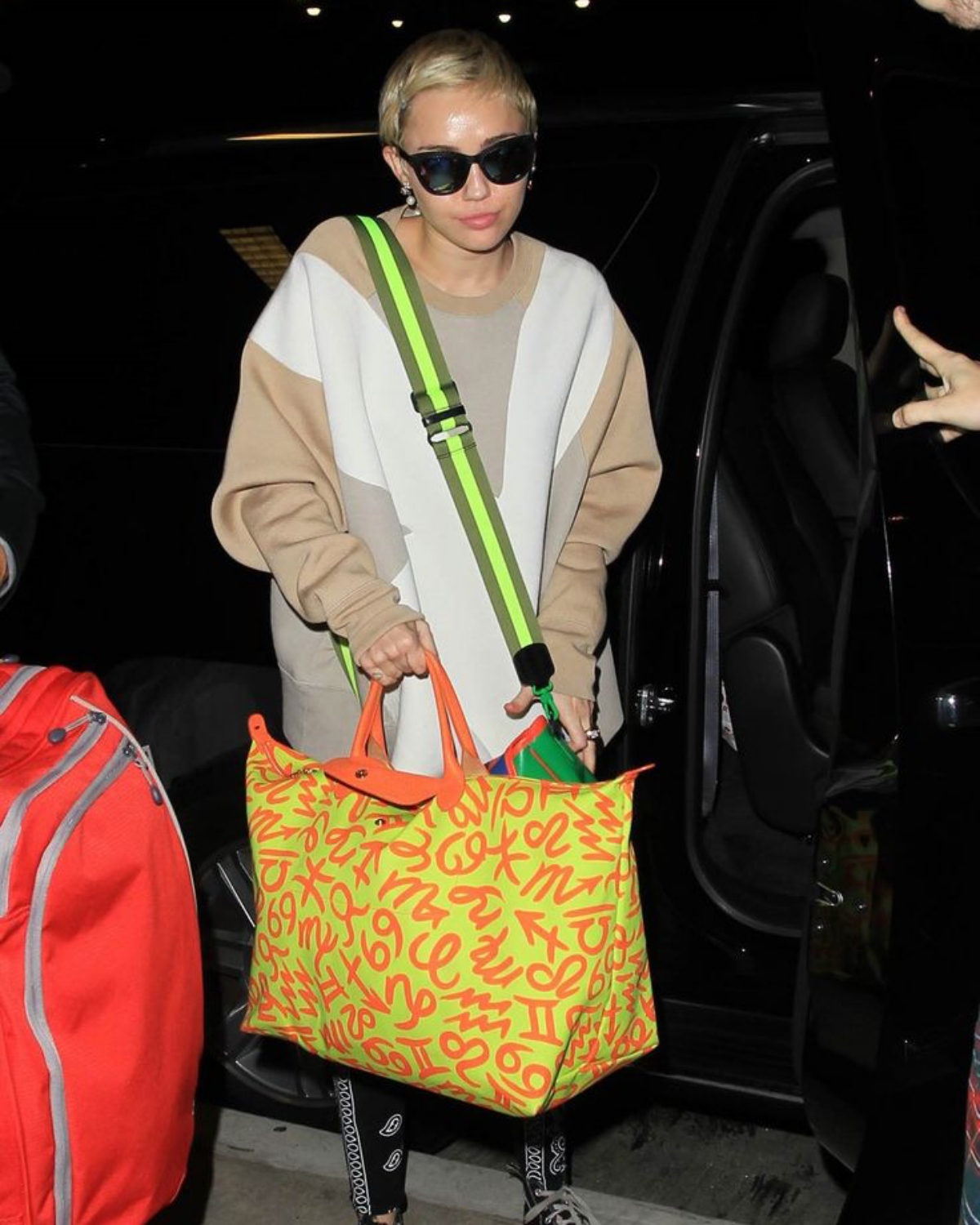 Miley Cyrus terlihat membawa tas Longchamp Le Pliage ketika tengah bepergian