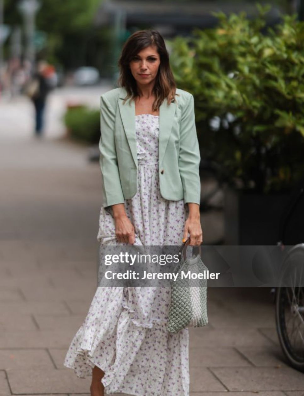 Anna Wolfers seen wearing a light green blazer, long maxi dress with floral print, a white and light green crochet bag and light green high heels on June 02, 2022 in Hamburg, Germany.