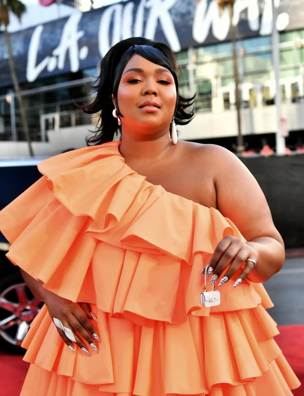 Lizzo membawa tas super mini dari Valentino Garavani