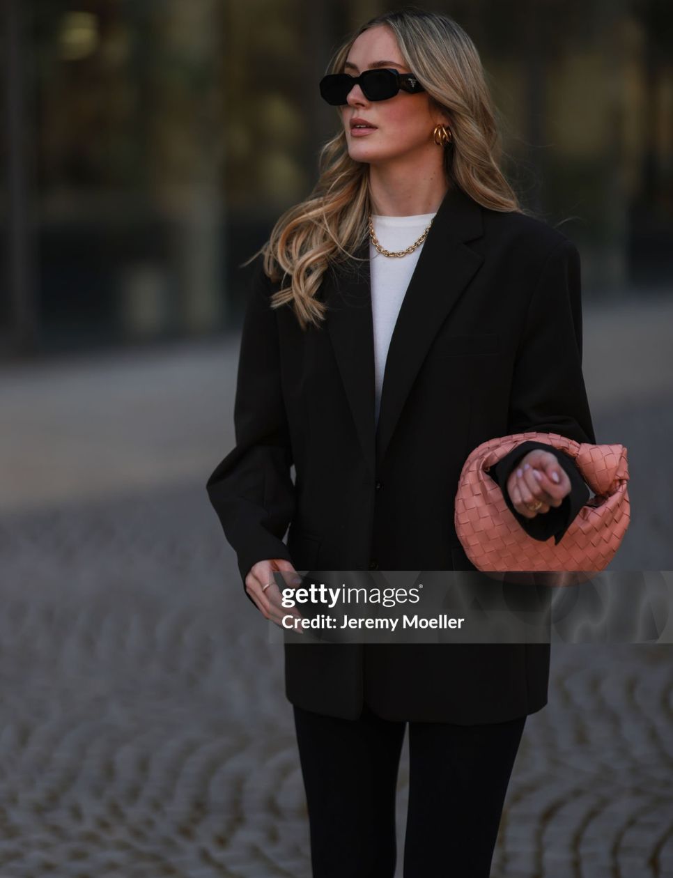 Luisa Maier seen wearing a black Prada sunglasses, gold necklace and gold earrings from Glambou, a white shirt from Aym, a black oversized blazer from The Frankie Shop, a pale orange Bottega Veneta Mini Jodie handbag and a black leggings from Calzedonia on March 21, 2022 in Munich, Germany. (Photo by Jeremy Moeller/Getty Images)