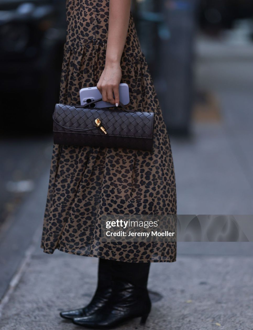 A Fashion Week guest seen wearing brown animal print long dress, Bottega Veneta brown woven leather Andiamo clutch bag, during the New York Fashion Week, on September 05, 2024 in New York City. (Photo by Jeremy Moeller/Getty Images)