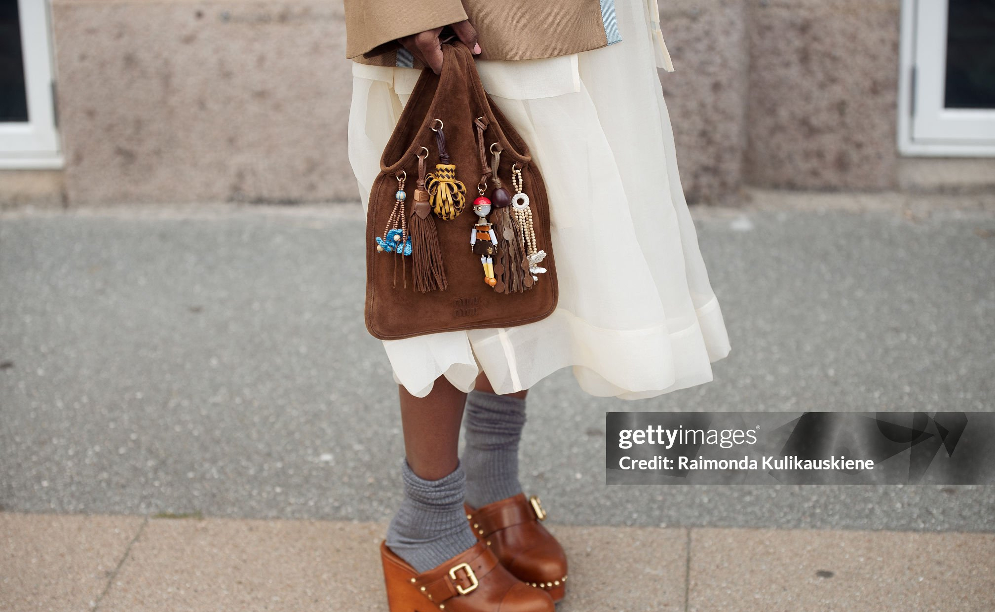 COPENHAGEN, DENMARK - AUGUST 06: Zufi Alexander wears white sheer skirt, grey socks, brown mules, brown jacket and a brown suede bag with charms during Copenhagen Fashion Week day three on August 06, 2025 in Copenhagen, Denmark. (Photo by Raimonda Kulikauskiene/Getty Images)