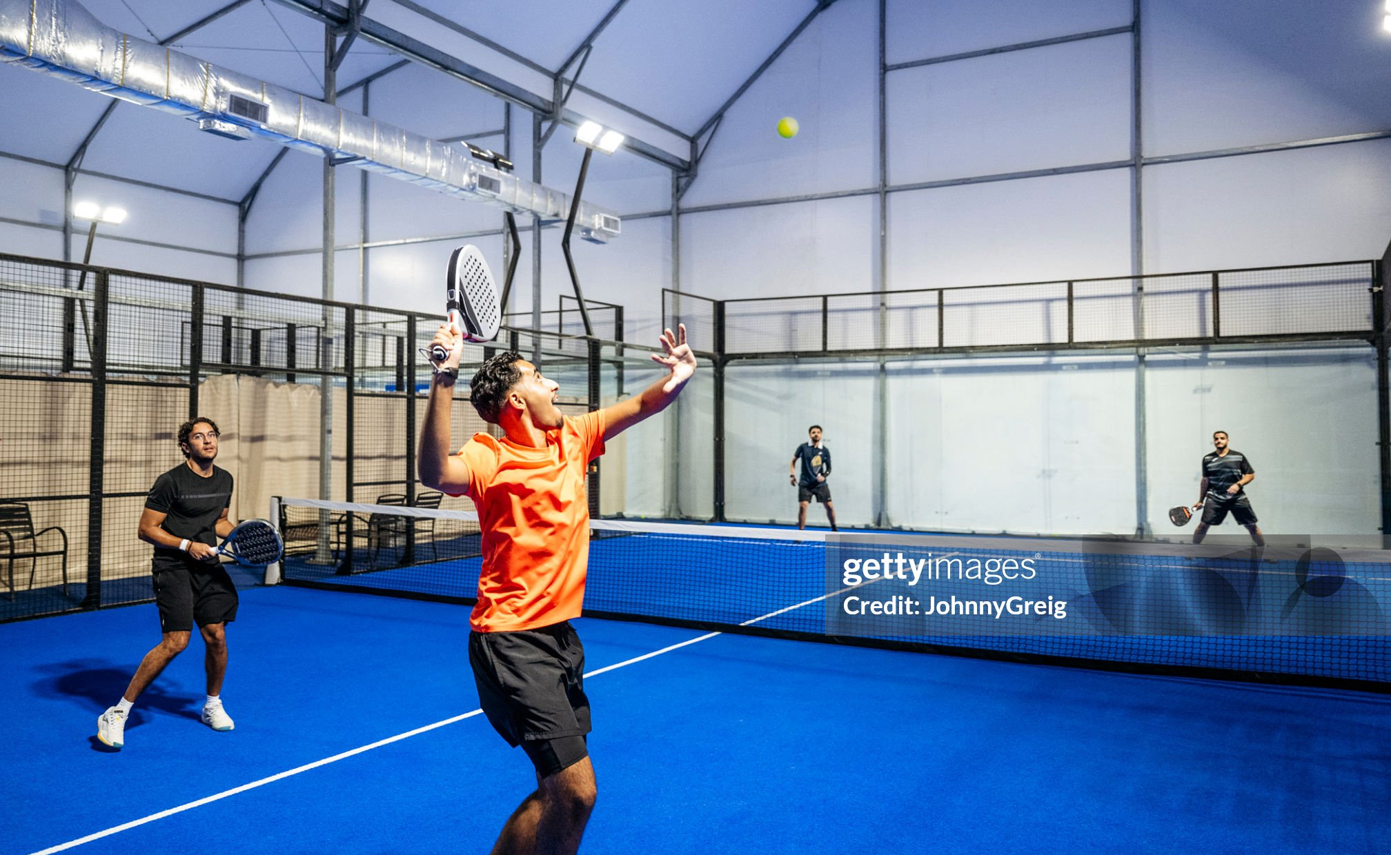 Young man concentrating with arm raised, tennis ball mid-air, playing padel tennis doubles, Jeddah, Saudi Arabia Getty Image