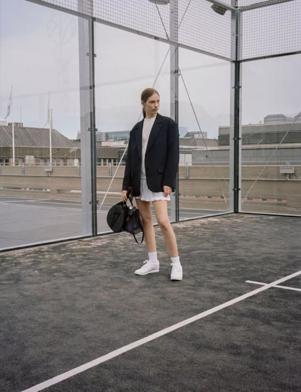 Seorang wanita yang berada di lapangan padel (sumber gambar: https://www.voguescandinavia.com/articles/the-begginers-guide-to-padel-swedens-trendiest-sport)