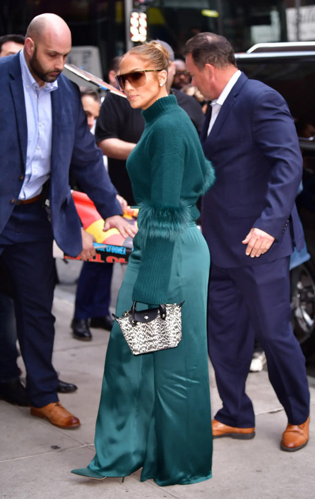 Jennifer Lopez memakai tas Longchamp Le Pliage