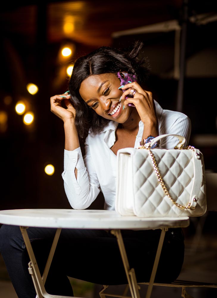 Woman in White Top and Black Pants Sitting Holding a cellphone (pexels.com)