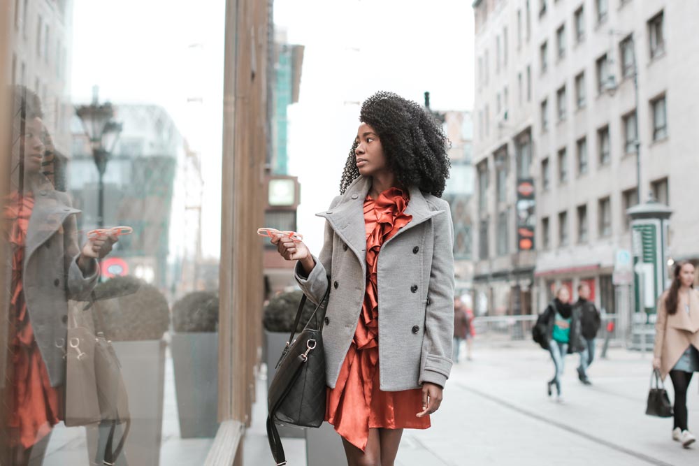 Selective Focus Photo of Woman in Gray Coat Walking by Store Window (pexels.com)